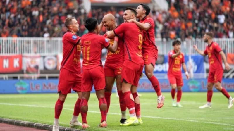 Pemain Persija Jakarta merayakan gol di Stadion GBK dengan latar belakang Jakmania yang bersorak.