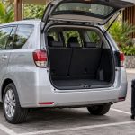 Mobil MPV dengan bagasi terbuka dan dua koper sebagai ilustrasi sewa mobil Labuan Bajo.